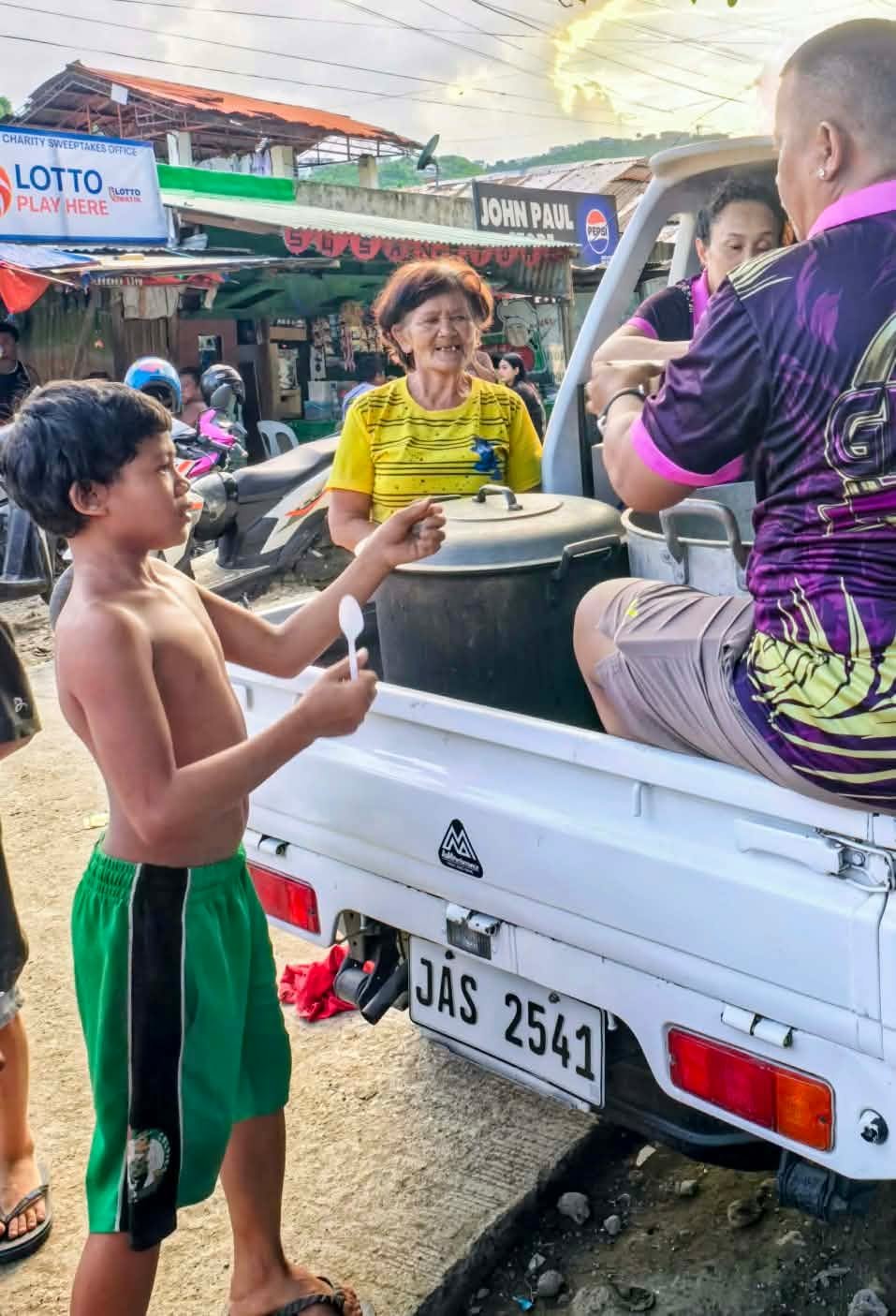 A young resident collecting food during a mobile community meal