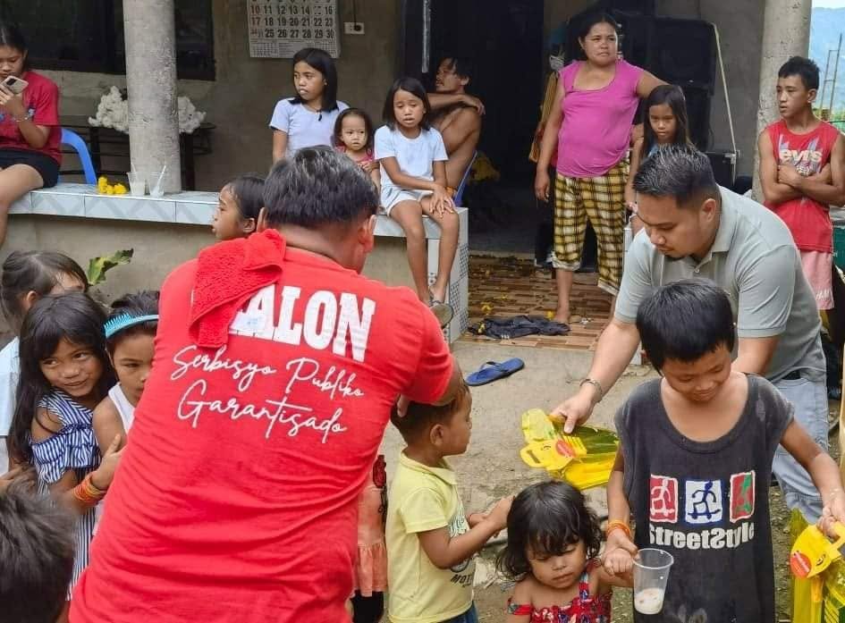 Volunteers handing food packs to children and families in the community