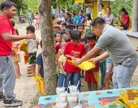 Children receiving food packs from volunteers during an outreach activity