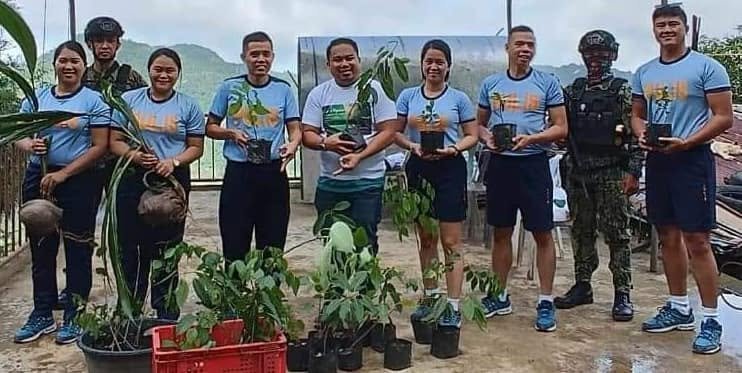 Community volunteers holding young trees during a planting activity